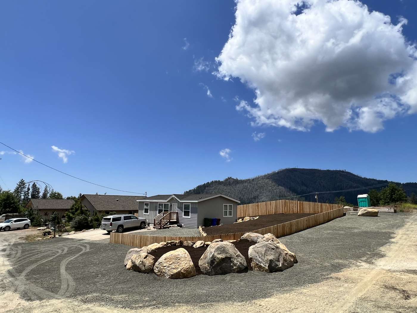 A cleared and graded lot with large boulders set in the middle