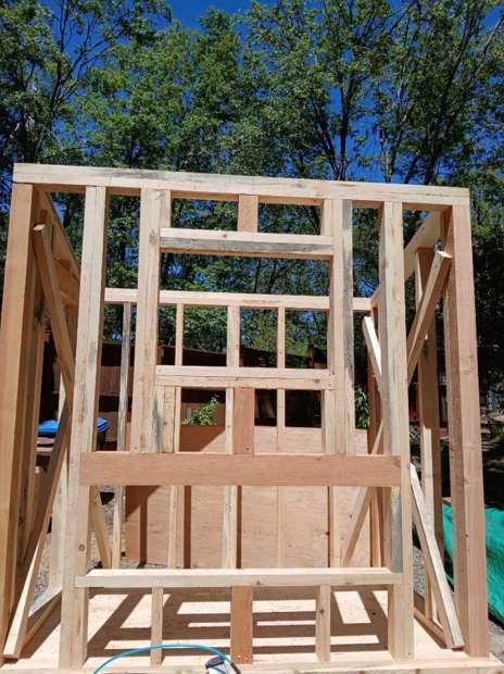 The frame of a small building going up in fresh milled lumber