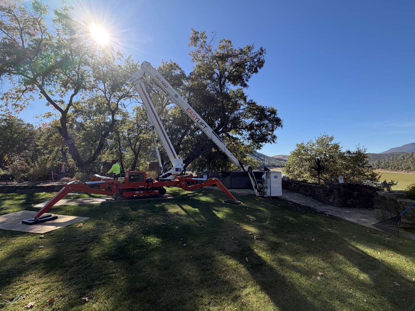 R2's spider lift set up on a lawn under oaks, hills and vineyard behind