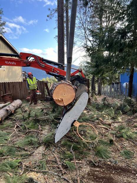 R2 crew member Mike finishes a cut and the excavator helps lift it up and out